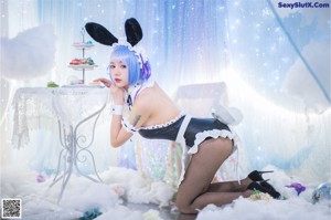 A woman dressed as a bunny holding a fluffy white ball.