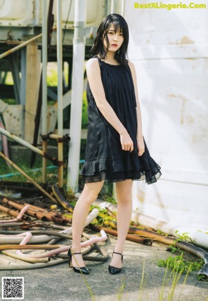 A woman in a black dress posing for a picture.