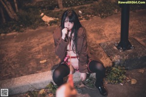 A woman in lingerie sitting on the side of a road.