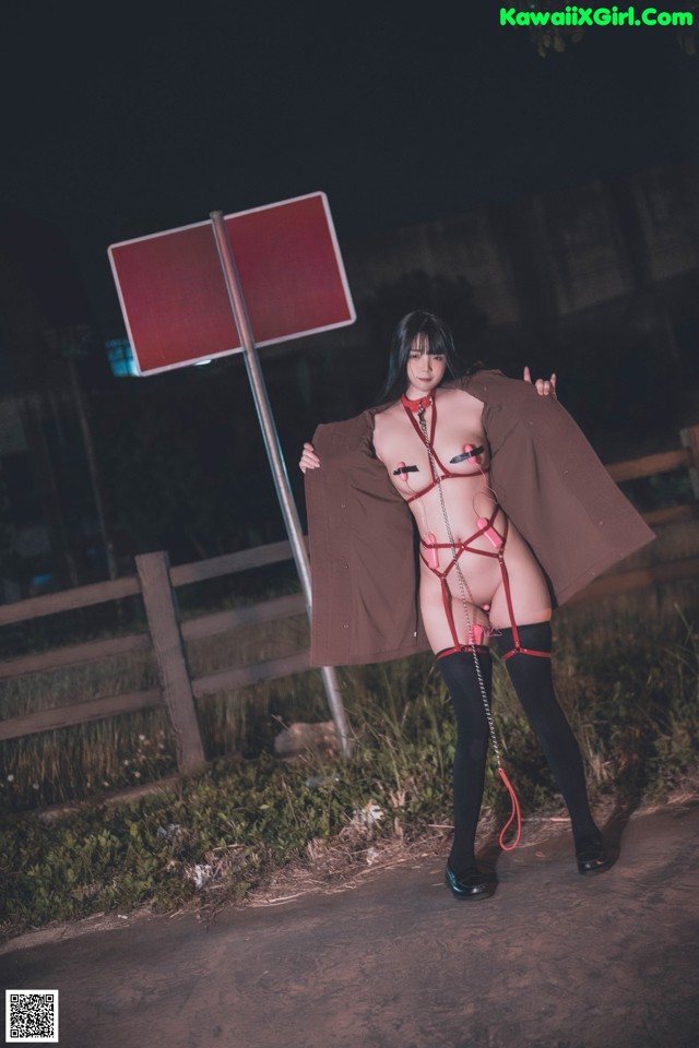 A woman in lingerie standing next to a no crossing sign.