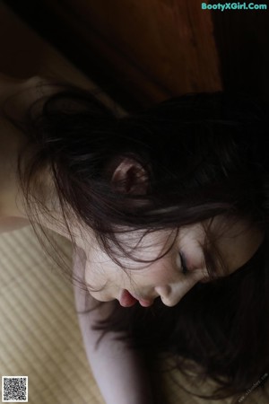 A naked woman laying on the floor in a room.