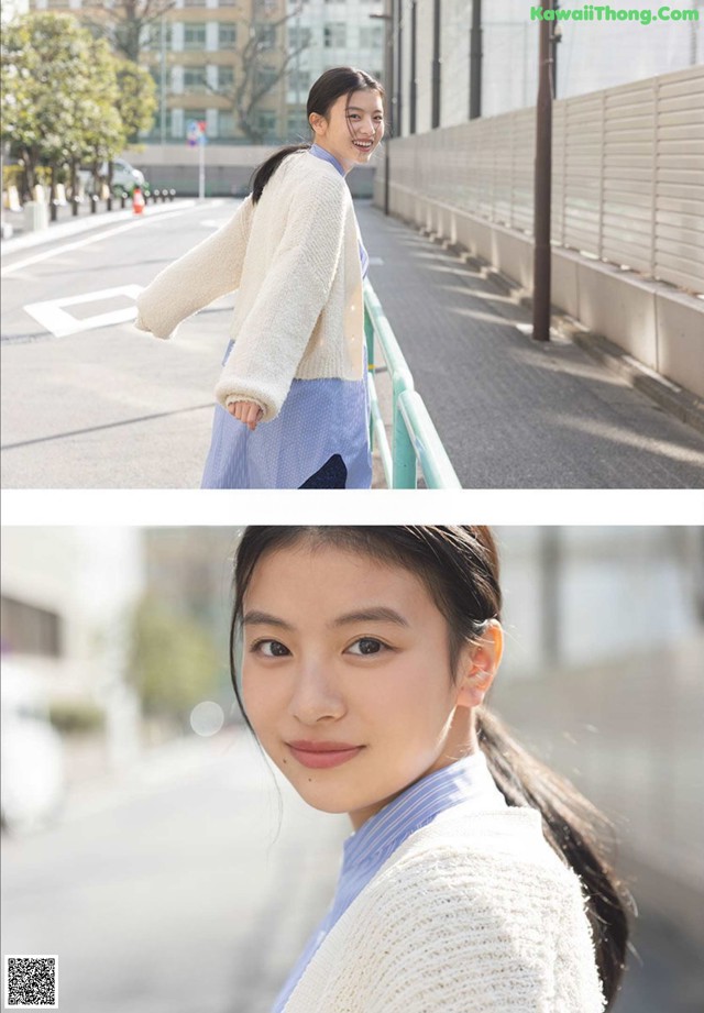 A woman in a white sweater and blue skirt standing on a bridge.