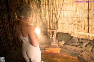 A woman in a white dress is sitting in a hot tub.