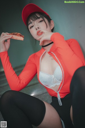 A woman sitting on the steps eating a slice of pizza.