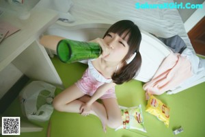 A woman sitting on the floor eating a snack.