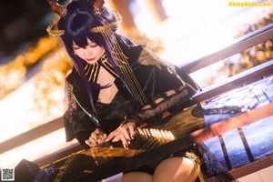 A woman sitting on a bench playing a musical instrument.