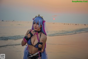 A woman with long purple hair sitting on the ground.