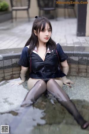 A woman in a school uniform sitting on a chair.