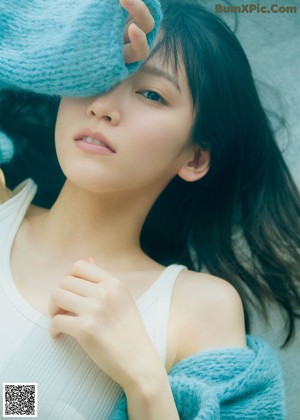 A woman sitting on the floor in a sheer blue dress.