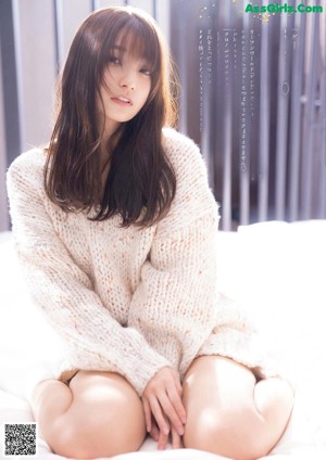 A woman laying on top of a bed with long brown hair.