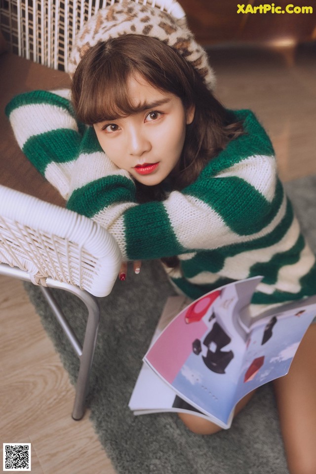 A woman sitting on a chair reading a book.