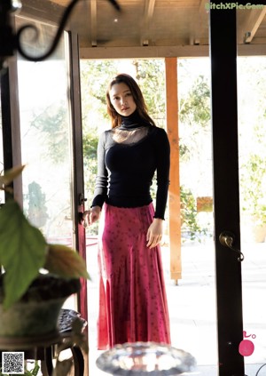 A woman standing in front of a glass door.