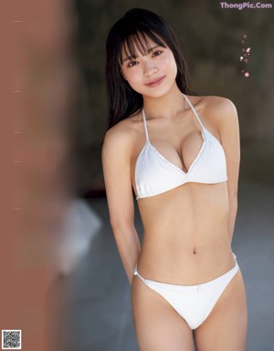 A woman in a bikini with a flower in her mouth.