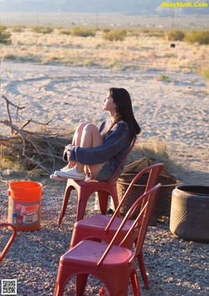 A woman standing in front of a joshua tree in the desert.